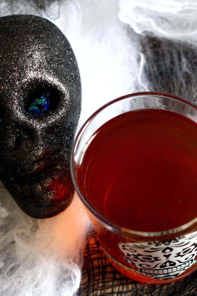 Halloween Cocktails Halloween cocktail surrounded by Halloween webbing and a black skull
