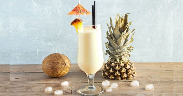 Pina Colada drink in front of coconut and pineapple