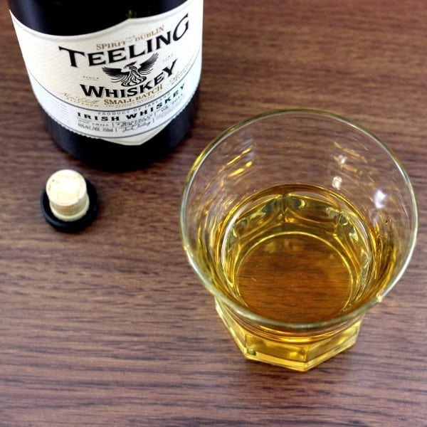 Overhead view of Teeling Small Batch Irish Whiskey bottle with glass of same